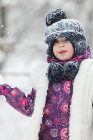 Little girl in pink jacket in winter forestの写真素材