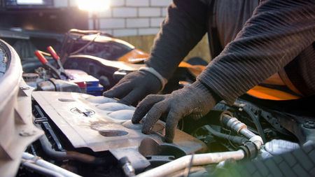 Car service. Mechanic man opening top of an engineの写真素材