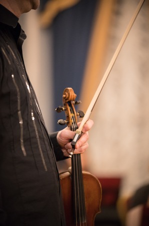 The violinist holds the violin in the concert hallの写真素材