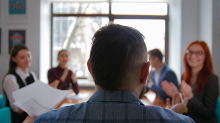 Business concept. A chief sitting at the conference and having a conversation with his subordinates. Back viewの写真素材