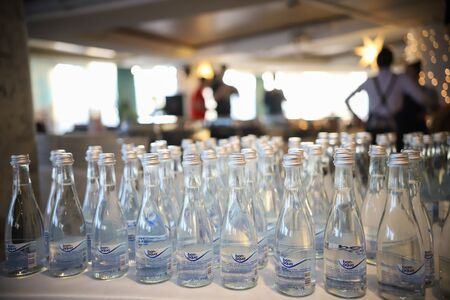 RUSSIA, KAZAN. 09-04-2019: Modern loft bar style. Bottles of water on the stand. People standing on the backgroundのeditorial素材