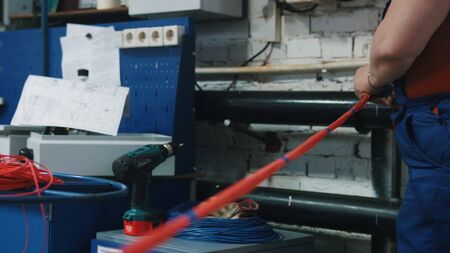 A man works with a bunch of wires. Camera moves from right to left and back.