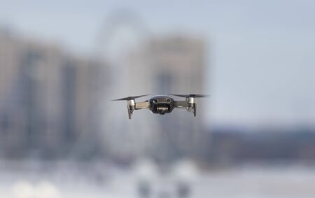 A flying quadcopter on the background of the city