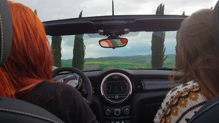 Two women sitting in the cabriolet and ridingの写真素材