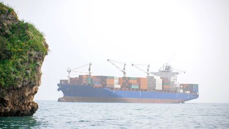 Freighter with multiple containers floats in the sea