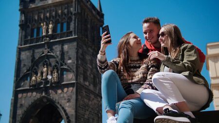 Company of friends laughing and look into the phone. Czech, Pragueの写真素材