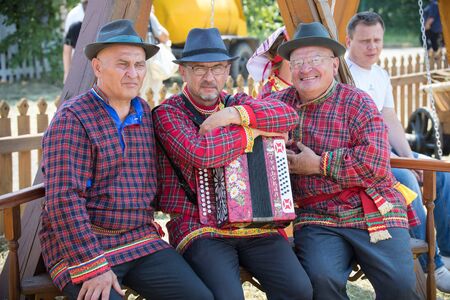 REPUBLIC OF TATARSTAN, RUSSIA: 04.07.2019 - Old men in traditional tatar clothes are siting on the bench with the accordeonのeditorial素材