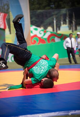 REPUBLIC OF TATARSTAN, RUSSIA: 04.07.2019 - Sabantui fighting competitions - One man knocks another downのeditorial素材