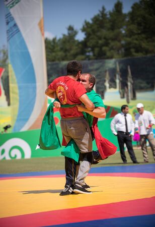 REPUBLIC OF TATARSTAN, RUSSIA: 04.07.2019 - Two fit men are diligently fighting at Sabantui competitions.のeditorial素材