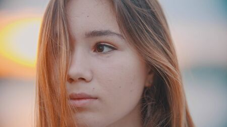 A portrait of teenage girl looking to the side - sunsetの写真素材