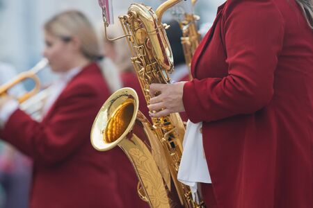 A wind instrument parade - a man in red costume playing saxophone