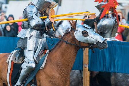 BULGAR, RUSSIA 11-08-2019: Knight Tournament at the medieval festival - a participant in full armor riding a horse and aiming in the opponentのeditorial素材