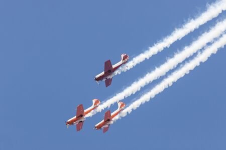 Three colorful jets flying in the sky and performing a show - smoke coming up from the planesの写真素材