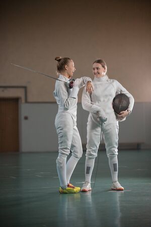 A portrait of two young women fencers laughingの写真素材