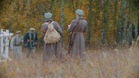 Two soldiers are going out of autumn forest