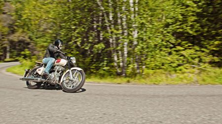 Biker is turning on the road in the forest -outdoorsの写真素材