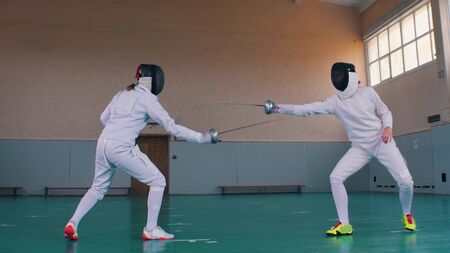 Two young fencers are training in the gym - indoor