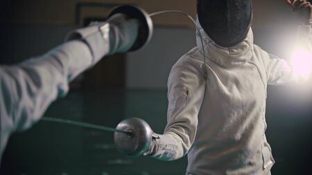 A picture of fencers fight in the school gym