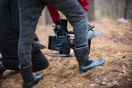 A man with camera in hand is filming in the forestの写真素材