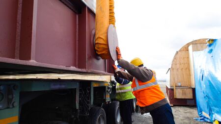 Cargo shipping - man worker fixing the flexible tube and preparing the cargo for loading