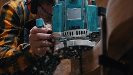 Carpentry - a woodworker polishes the wooden detail - sawdust falling down from the detail because...