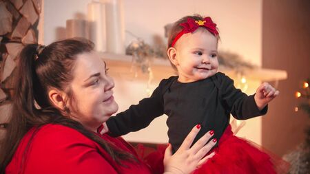 Christmas concept - A plump smiling woman holding her little baby daughter