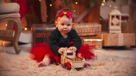 Christmas studio - a little cute baby girl playing with a toy carの写真素材
