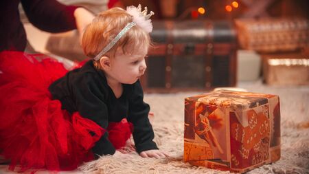 Christmas concept - A cute little baby playing with a gift boxの写真素材