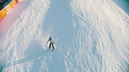 Snowboarding - a person skating down the mountain. Mid shotの写真素材