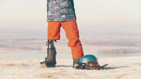 A man with prosthetic leg standing on the board on the field. Mid shotの写真素材