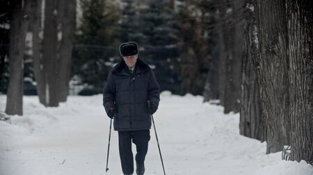 Elderly grandfather - old grandfather doing hiking outdoors at winter timeの写真素材