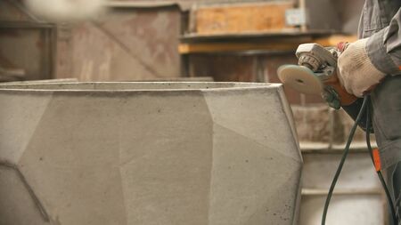 Concrete industry - polishing a big concrete figure with a grinder