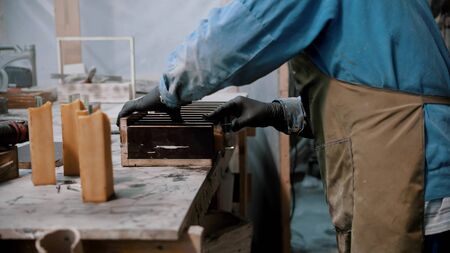 Concrete industry - worker preparing glass and silicone for the working on the souvenir statue -...