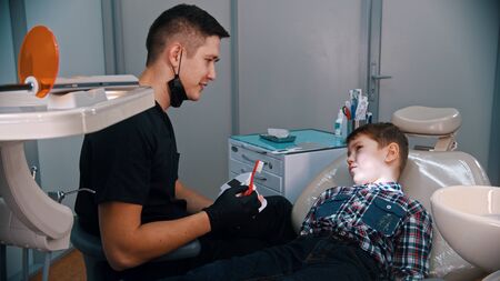 A little boy having a treatment in the modern dentistry - talking about the hygiene and brushing...