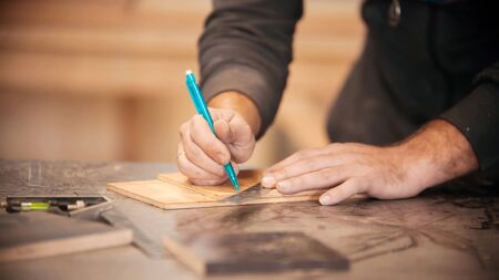 Carpentry working - making marks on the wood with a pencilの写真素材