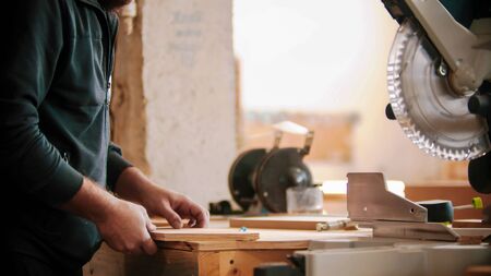 Carpentry working - a man making marks on the plywoodの写真素材