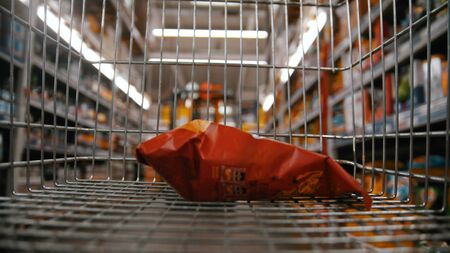 Grocery trolley in the supermarket - buying chips. mid shotの写真素材