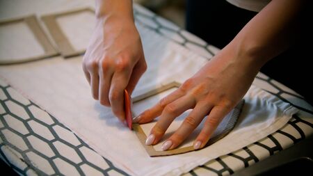Young woman seamstress making marks using the soap and formの写真素材