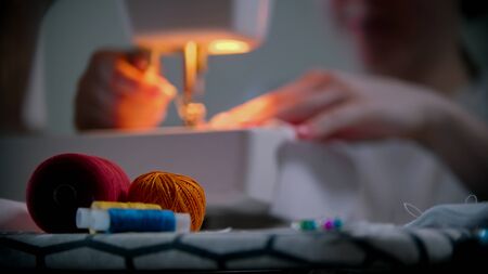 Young woman seamstress working with clothes and pins