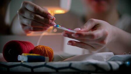 Young woman designer putting pins in the holder. Mid shot
