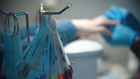 Manicure master doing manicure in the office - nail polish samples on the foregroundの写真素材