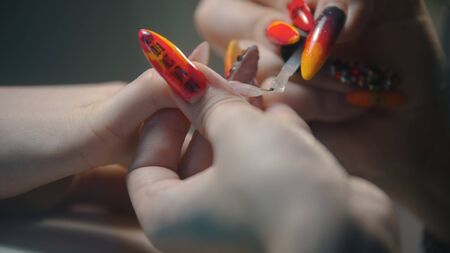 Doing manicure in salon - applying clear base on the natural nailの写真素材