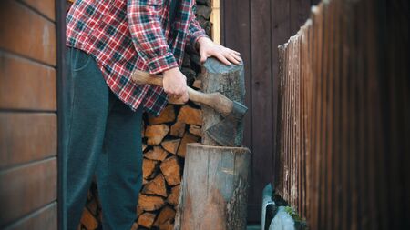 Chopping wood with an ax in woodpile - putting log on the stump
