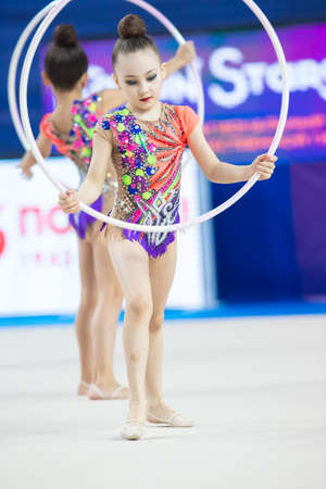 12-03-2020 KAZAN, RUSSIA: teen girls with white hoops performing on the gymnastic tournamentのeditorial素材