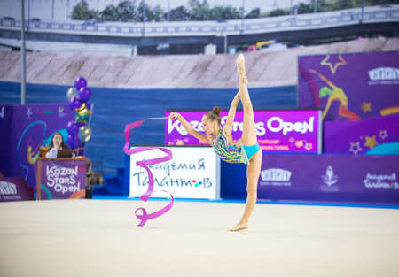 12-03-2020 KAZAN, RUSSIA: girl in bright swim costume performing with purple ribbon on the gymnastic tournamentのeditorial素材
