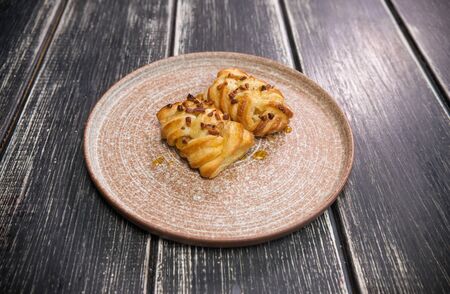 Square cookies with nuts on top on the plate