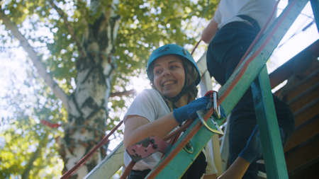 Rope adventure - couple walking upstairs to the attraction area - woman smiling