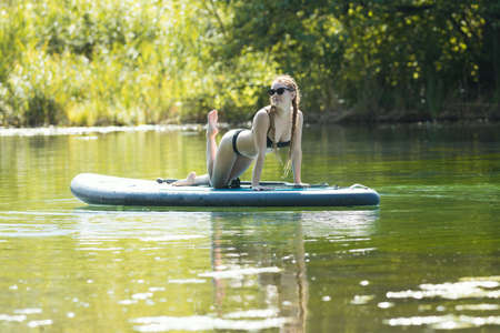 Rafting - young pretty woman in black swimsuit posing on the raftの写真素材