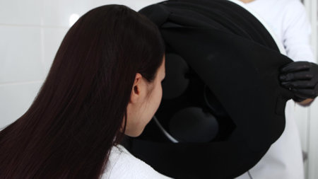Body massage - young woman puts her head under the black clothの写真素材