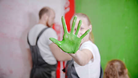 Family painting walls - A womans palm covered with a green color paintの写真素材